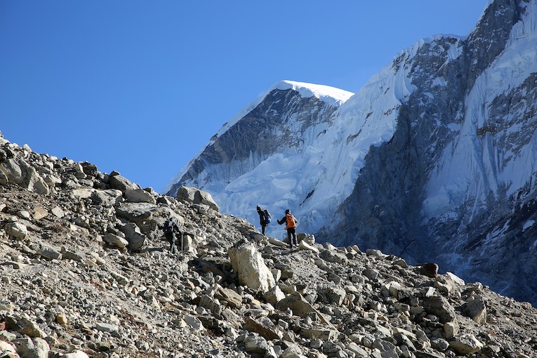 two people standing on rocky mountain