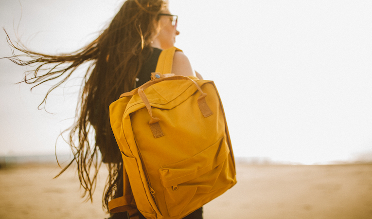 girl on beach with backpack