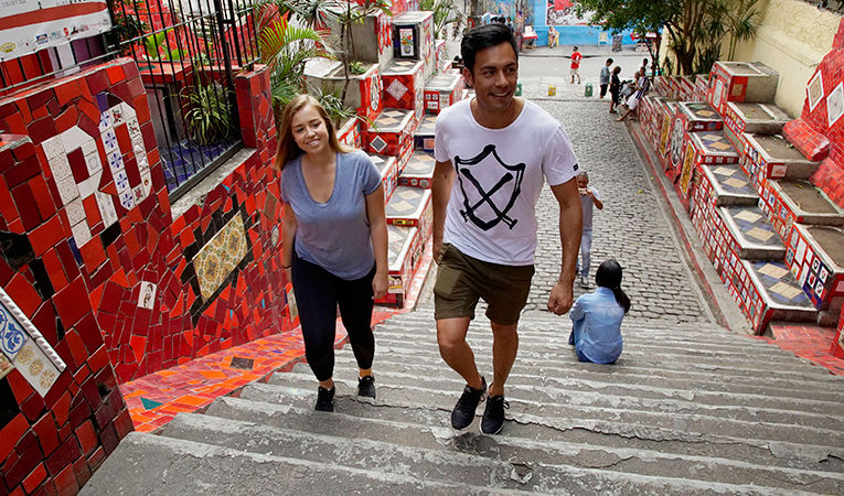 Chloe and Reuben of Global Travel Academy walking up steps smiling