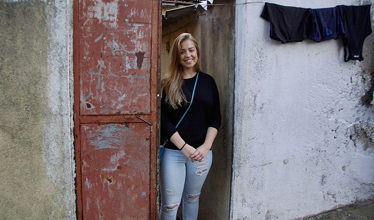 Chloe posing in a doorway smiling and volunteering