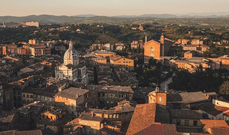 Rolling hills and warm, sunny buildings in Siena, Italy