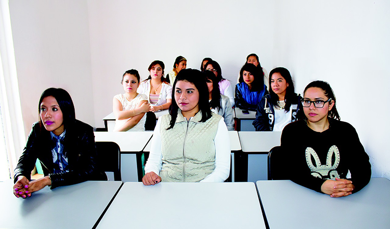 women sitting at desks listening attentively