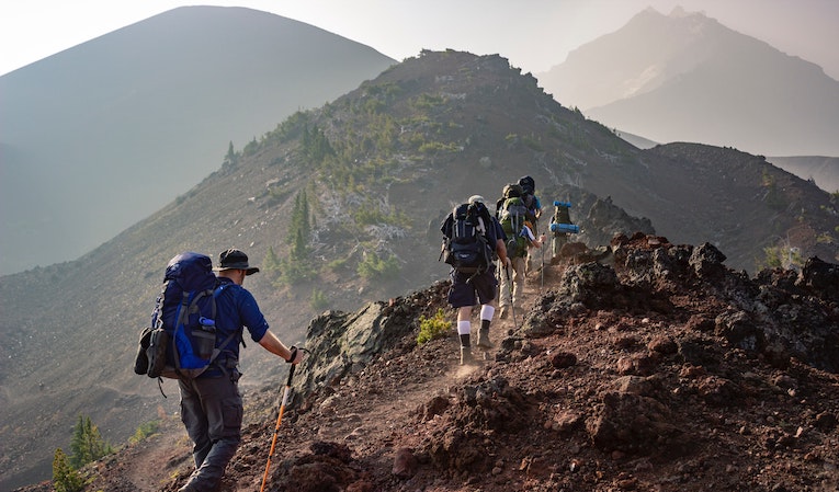 group of people hiking a rocky trail in oregon